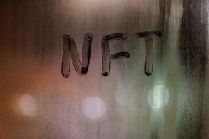 das wort nft - nicht fungibles token handschriftlich auf beschlagenem fensterglas in der nacht foto