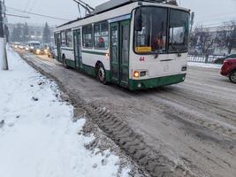 tula, russland 21. november 2020 oberleitungsbus, der bei wintertageslicht unter schnee auf der straße am bahnhof ankommt. foto