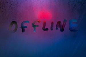 Wort Offline-Handschrift auf nebligem Glas mit kalter neonblauer Hintergrundbeleuchtung foto