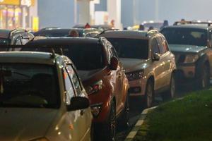 Autos, die in nebligen Nächten während der Versorgungskrise an der Tankstelle im Stau stecken foto