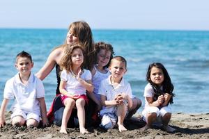 Gruppenporträt von Kindern mit Lehrer am Strand foto