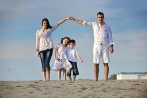 Familie am Strand mit Heimzeichen foto