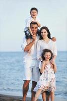 glückliche junge familie hat spaß am strand foto