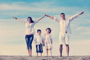 Familie am Strand mit Heimzeichen foto