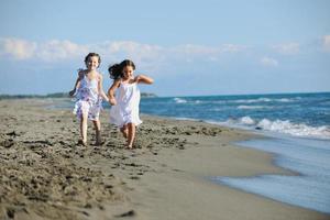 süße kleine Mädchen, die am Strand laufen foto