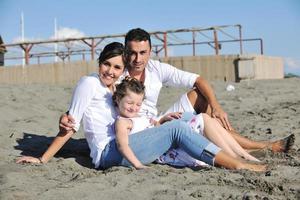 glückliche junge familie hat spaß am strand foto