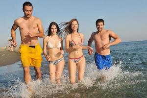 glückliche junge Leute haben Spaß am Strand foto