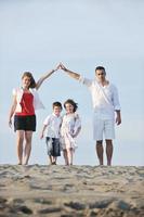 Familie am Strand mit Heimzeichen foto