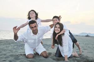 glückliche junge familie hat spaß am strand foto