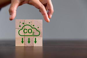 Unternehmen streben Netto-Null-Treibhausgasemissionen an. CO2-Gutschriftkonzept. Handelbares Zertifikat, um die Industrie in Richtung niedriger Emissionen bei den Effizienzkosten zu treiben. holzwürfel mit abnahme co2 foto
