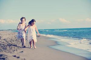 süße kleine Mädchen, die am Strand laufen foto