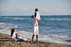 glückliche junge familie hat spaß am strand foto