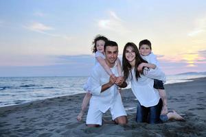 glückliche junge familie hat spaß am strand foto