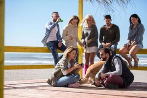 gruppe von freunden, die sich am herbsttag am strand amüsieren foto