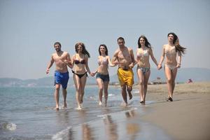 Happy People Group hat Spaß und läuft am Strand foto