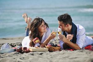 junges Paar beim Picknick am Strand foto