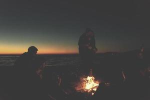 freunde, die sich am herbsttag am strand vergnügen foto