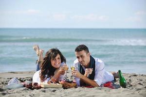 junges Paar beim Picknick am Strand foto