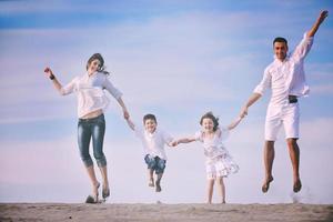 Familie am Strand mit Heimzeichen foto