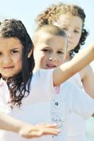 glückliche Kindergruppe, die am Strand spielt foto