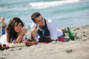 junges Paar beim Picknick am Strand foto