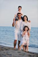 glückliche junge familie hat spaß am strand foto