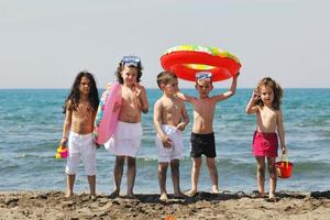 Kindergruppe hat Spaß und spielt mit Strandspielzeug foto