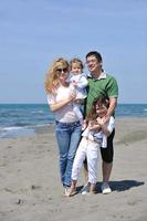 glückliche junge familie hat spaß am strand foto