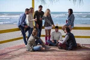 gruppe von freunden, die sich am herbsttag am strand amüsieren foto