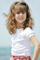 kleines weibliches Kinderporträt am Strand foto