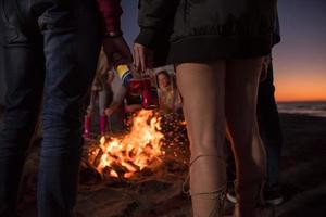 freunde, die sich am herbsttag am strand vergnügen foto