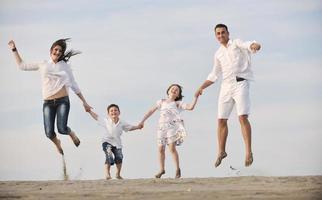 glückliche junge familie hat spaß am strand foto