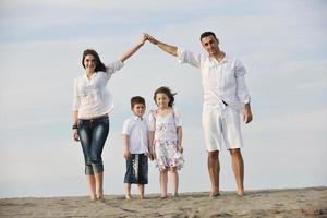 Familie am Strand mit Heimzeichen foto