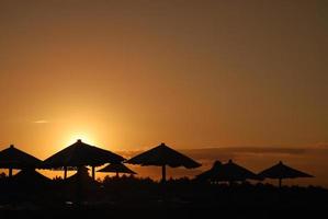 Sonnenschein am Strand mit Sonnenschirmen Silhouette foto