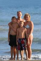 Familienporträt am Strand in den Sommerferien foto