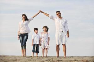 Familie am Strand mit Heimzeichen foto