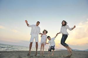 glückliche junge familie hat spaß am strand foto