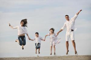 Familie am Strand mit Heimzeichen foto