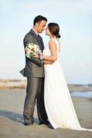 romantische Strandhochzeit bei Sonnenuntergang foto