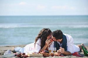 junges Paar beim Picknick am Strand foto