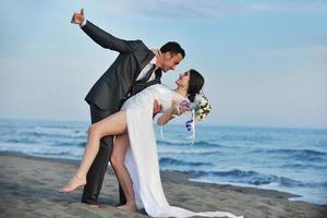 romantische Strandhochzeit bei Sonnenuntergang foto