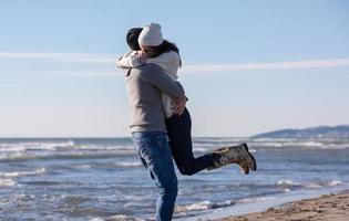 Liebendes junges Paar an einem Strand am sonnigen Herbsttag foto