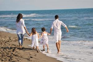 glückliche junge familie hat spaß am strand foto