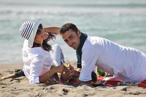 junges Paar beim Picknick am Strand foto