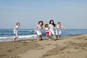 glückliche Kindergruppe, die am Strand spielt foto