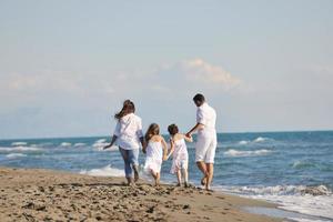 glückliche junge familie hat spaß am strand foto