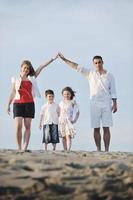 Familie am Strand mit Heimzeichen foto