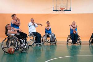 Teams von Basketballmannschaften mit Behinderungen wärmen sich auf und machen Dehnübungen, bevor das Training beginnt foto