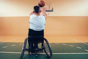 ein Foto eines Kriegsveteranen, der in einer modernen Sportarena Basketball spielt. das Konzept des Sports für Menschen mit Behinderungen