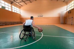 ein Foto eines Kriegsveteranen, der in einer modernen Sportarena Basketball spielt. das Konzept des Sports für Menschen mit Behinderungen